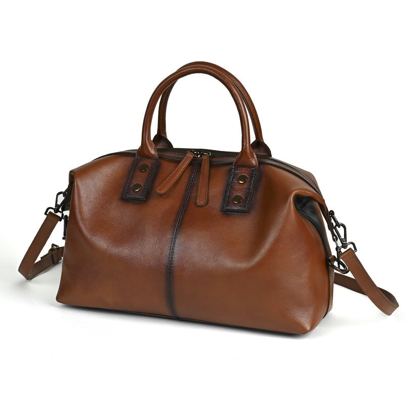 Women's retro leather handbag in brown, angled view highlighting soft leather texture and top handles