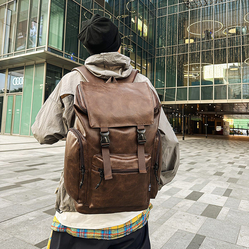 Person wearing a brown leather backpack in an urban setting