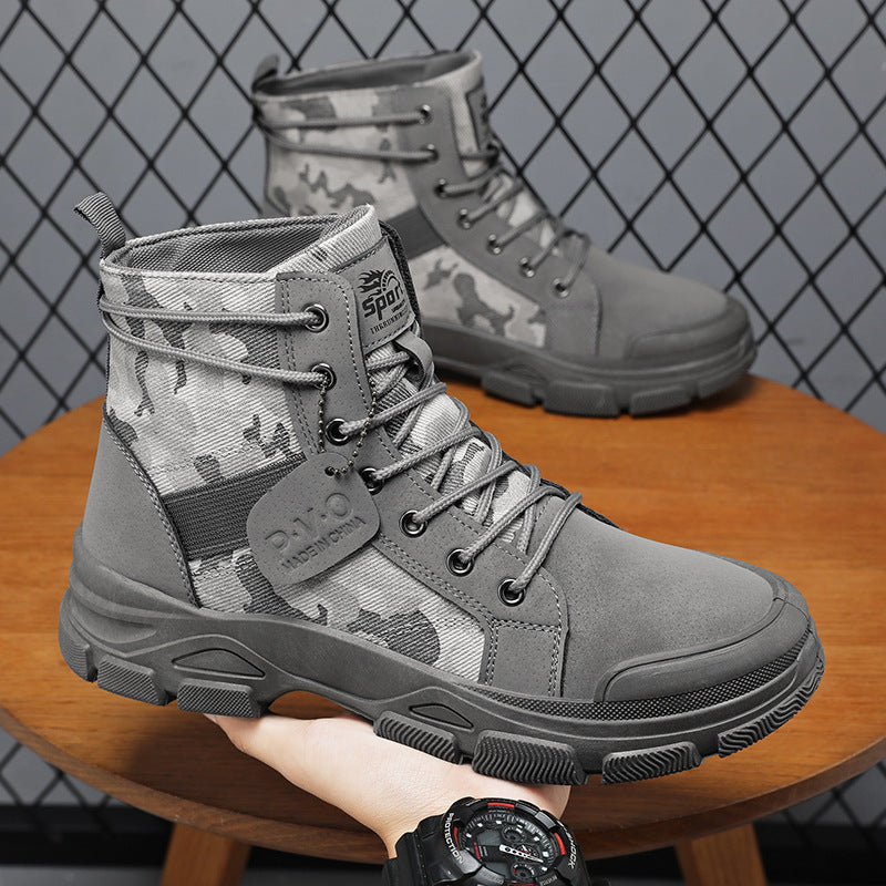 Gray camouflage boots on a wooden stool with a grid-patterned wall in the background