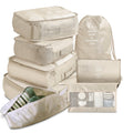 Set of beige travel packing cubes and bags on a white background
