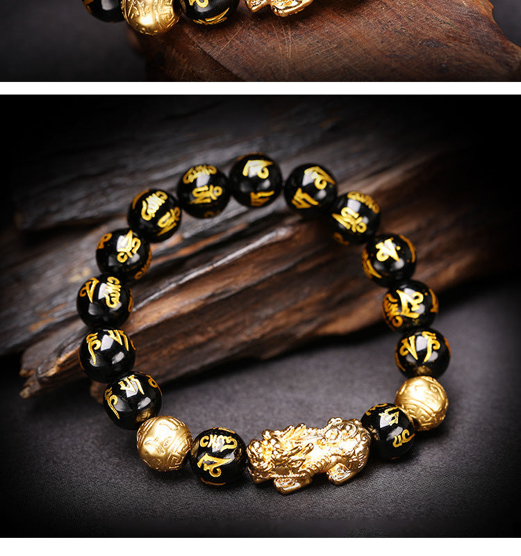 Black and gold beaded bracelet with intricate designs on a dark surface