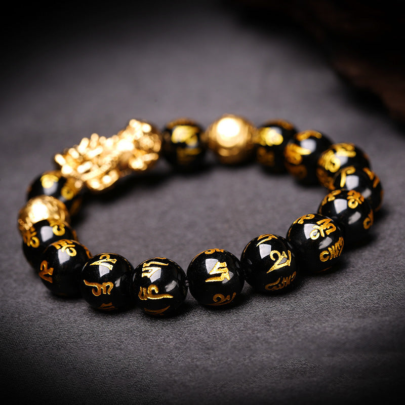 Black beaded bracelet with gold accents on a dark background