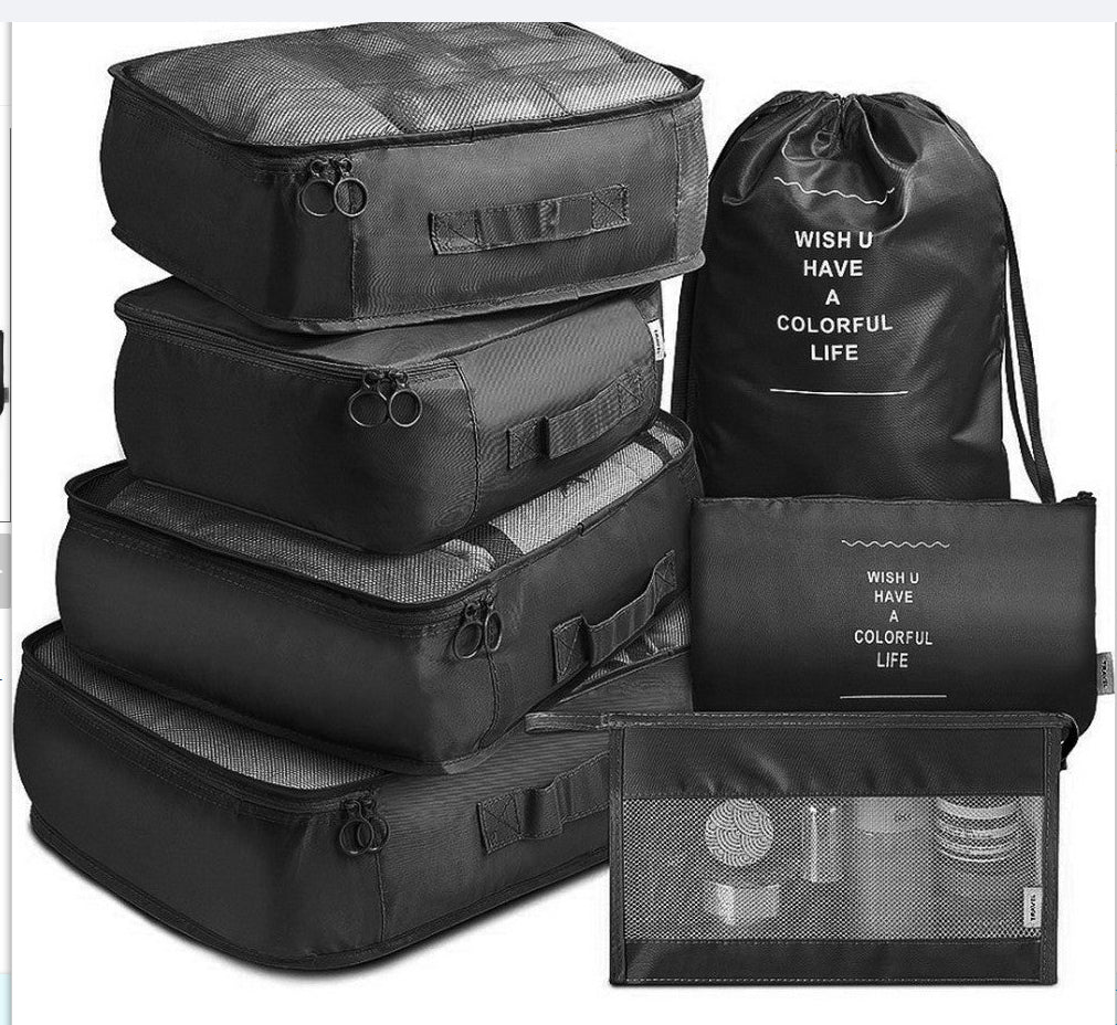 Set of black travel packing cubes with drawstring bag on a white background