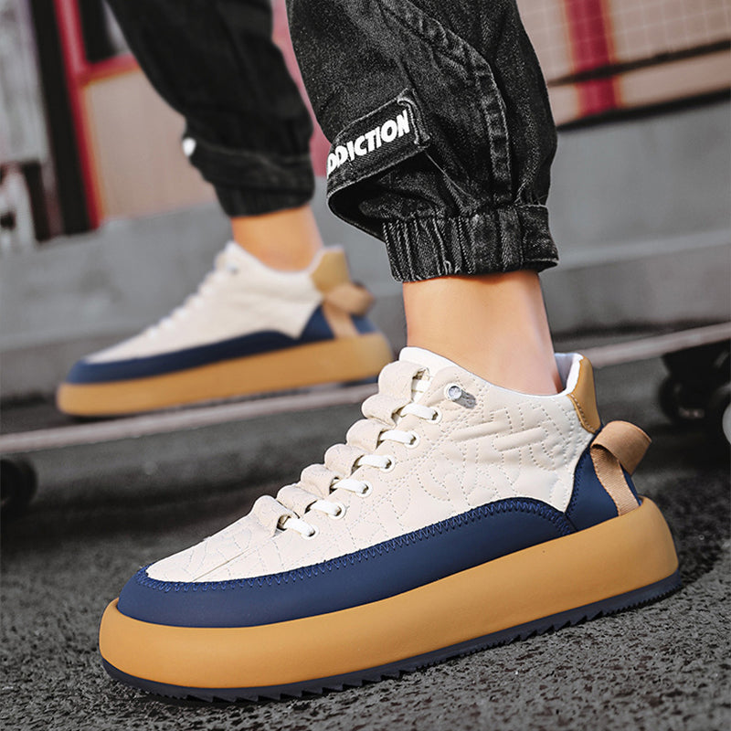 White, blue, and brown sneakers worn with black pants on a blurred background
