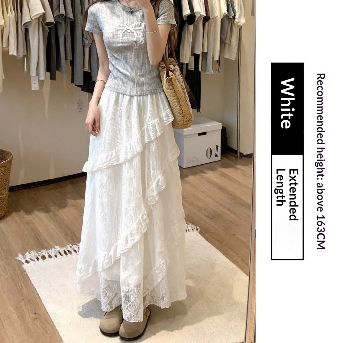 Woman wearing a light blue top and white lace skirt in a clothing store.