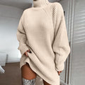 Person wearing a beige oversized sweater in a minimal indoor setting