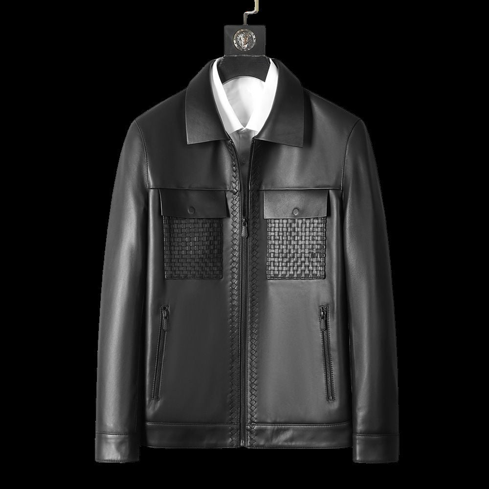 Black leather jacket with textured patch on a hanger against a black background