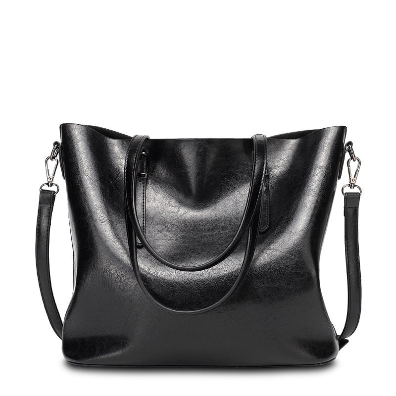 Women's retro oil wax leather tote bag in black, front view on white background with dual handles and adjustable crossbody strap