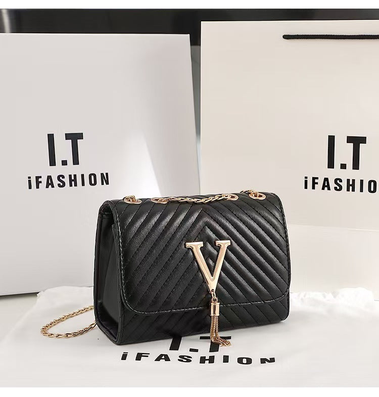 Black quilted handbag with gold chain and tassel on a white background with 'I.T iFashion' branding.