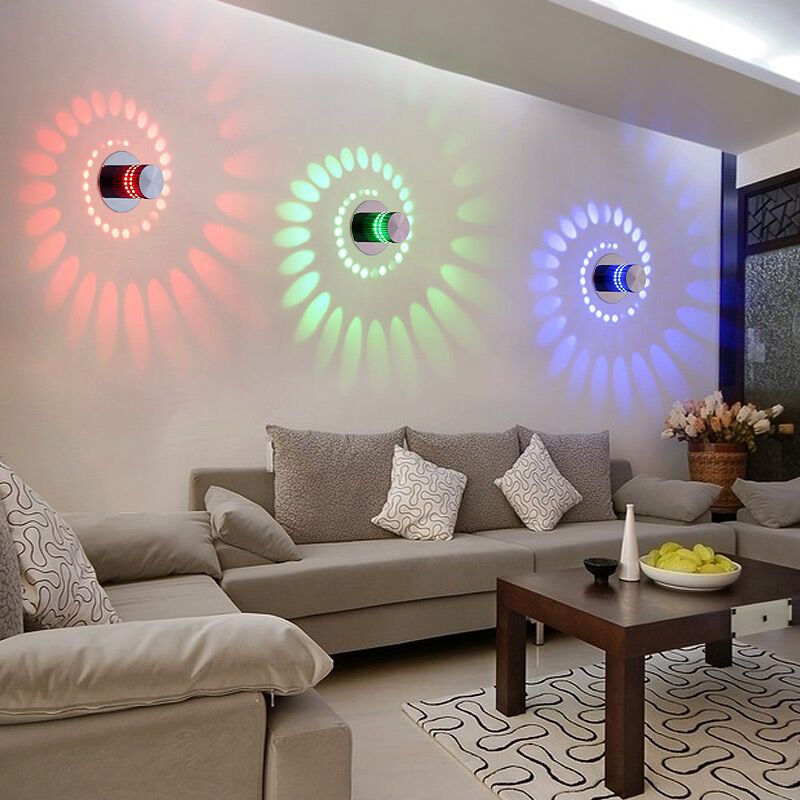 Living room with a gray sectional sofa, decorative pillows, and a coffee table with colorful wall lights.