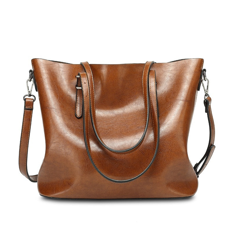 Women's oil wax leather tote bag in brown, straight front view showing smooth leather surface and adjustable crossbody strap