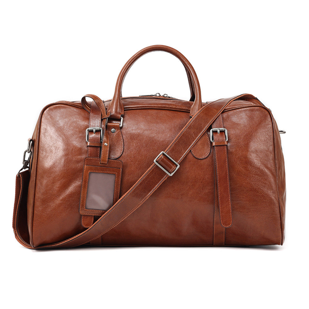 Brown leather duffel bag with a shoulder strap on a white background