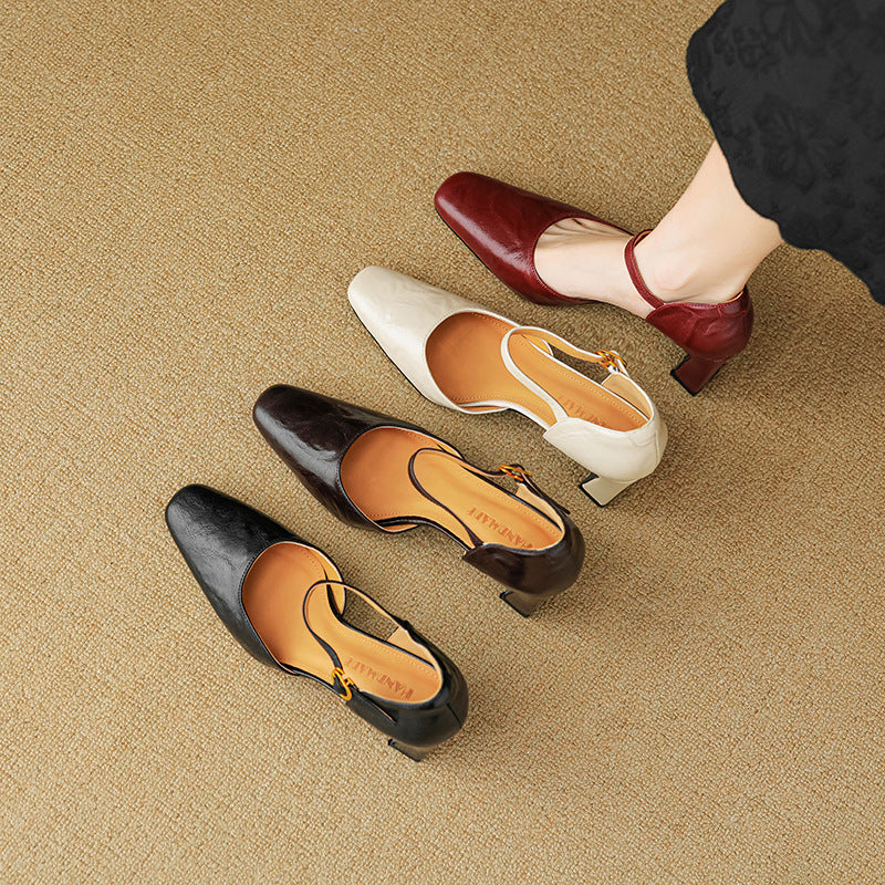 Four pointed-toe slingback pumps with low block heels are arranged on a beige carpet. One shoe is being worn, with a person's lower leg and foot visible in the top-right corner.