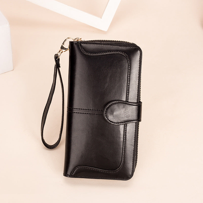 Black wallet with a strap on a beige background