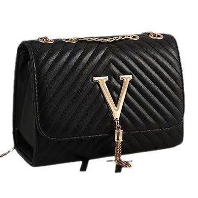 Black quilted handbag with gold chain and 'V' emblem on a white background