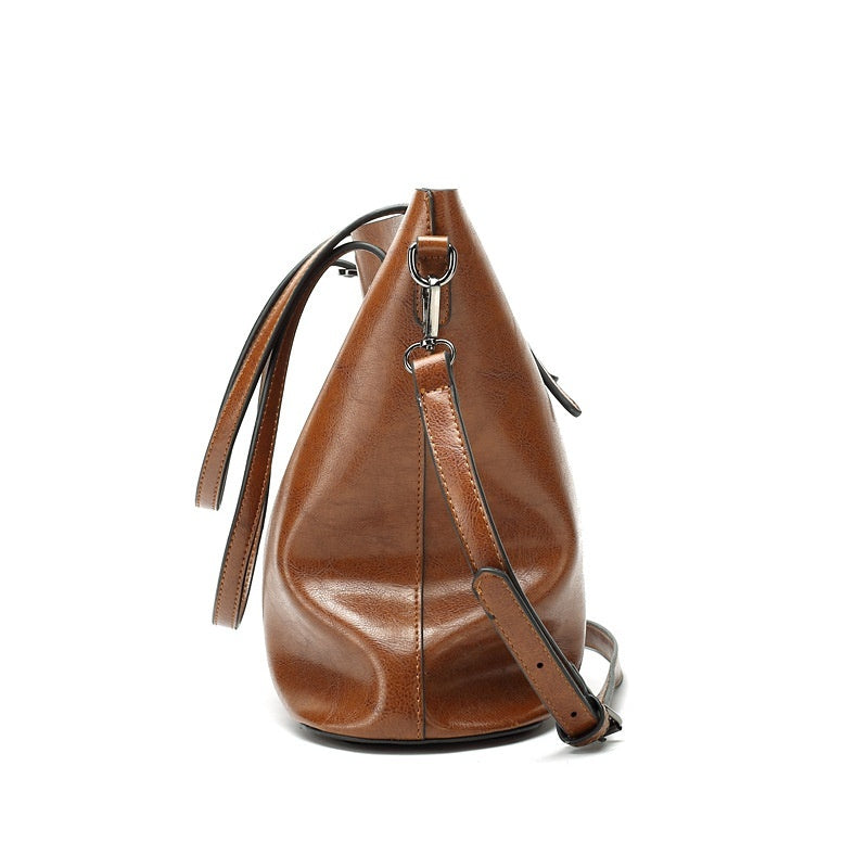 Women's retro leather tote bag in brown, side profile view showing structured base, stitching detail and strap attachment