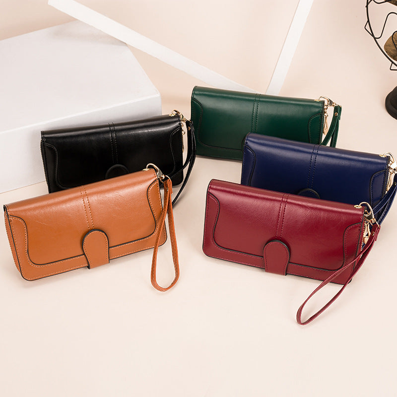 Four leather wallets in different colors on a light surface