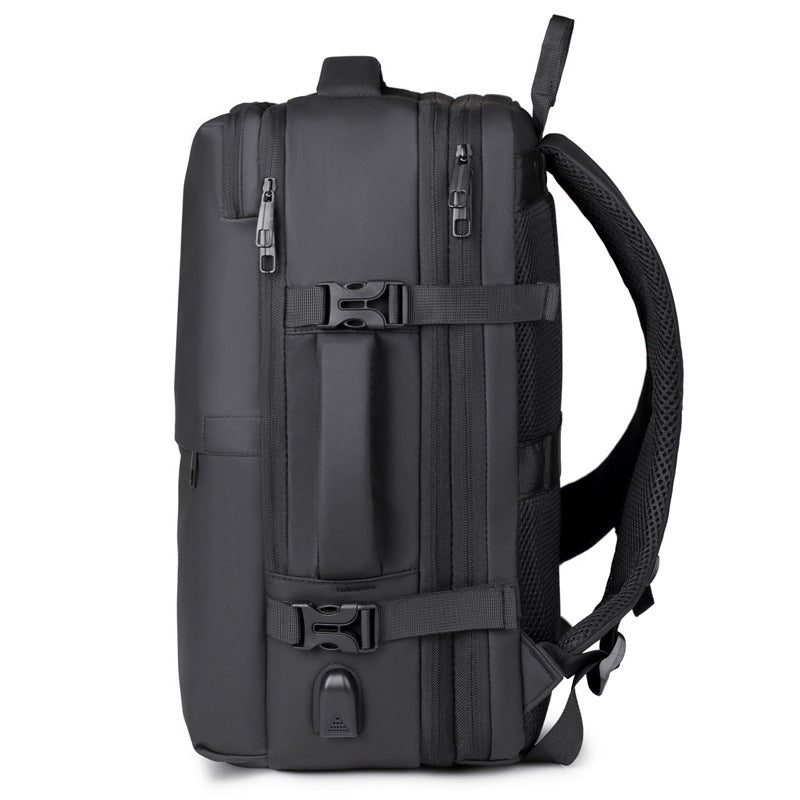A black minimalist backpack with a top carry handle, side compression straps, and a front zippered pocket, shown against a clean white geometric background.