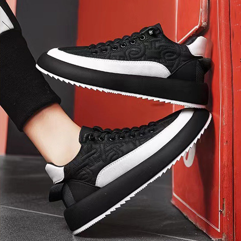 Black and white sneakers being worn against a red background