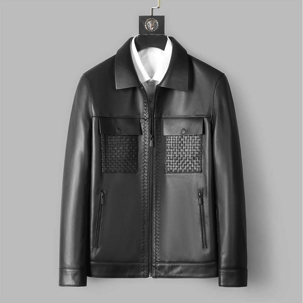 Black leather jacket with textured panels on a gray background