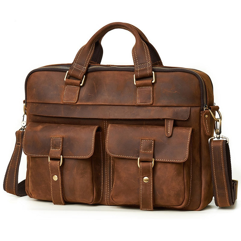 A brown distressed leather briefcase with dual top handles, a detachable shoulder strap, and multiple front utility pockets, photographed on a clean white background.