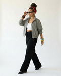 Woman wearing a checkered shirt, black pants, and a red headscarf on a white background