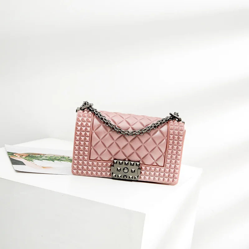 Pink quilted handbag with a chain strap on a white background
