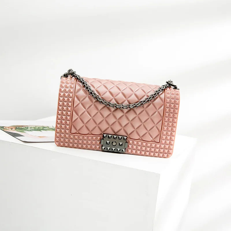 Pink quilted handbag with a chain strap on a white background