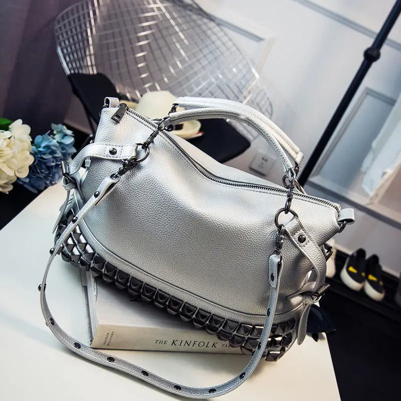 Silver handbag with black accents on a white surface