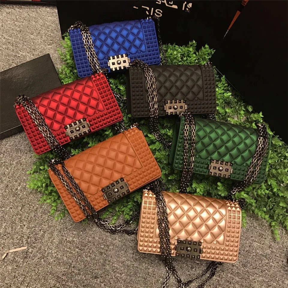 Collection of colorful quilted handbags on a textured surface with greenery.