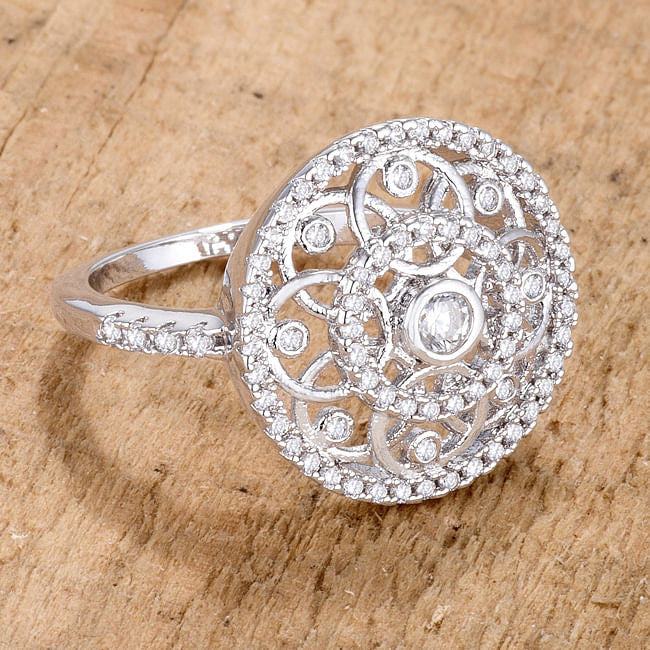 Silver ring with intricate design on a wooden surface