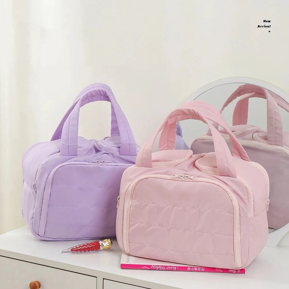 Two pink and purple bags on a white surface with a neutral background