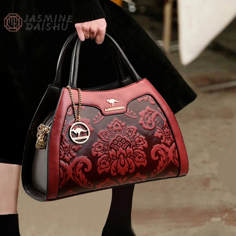 Red and black handbag with intricate design held by a person, brand 'Jasmine Daishu' visible.