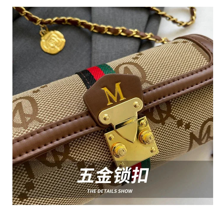 Close-up of a gold lock on a patterned bag with 'M' branding.