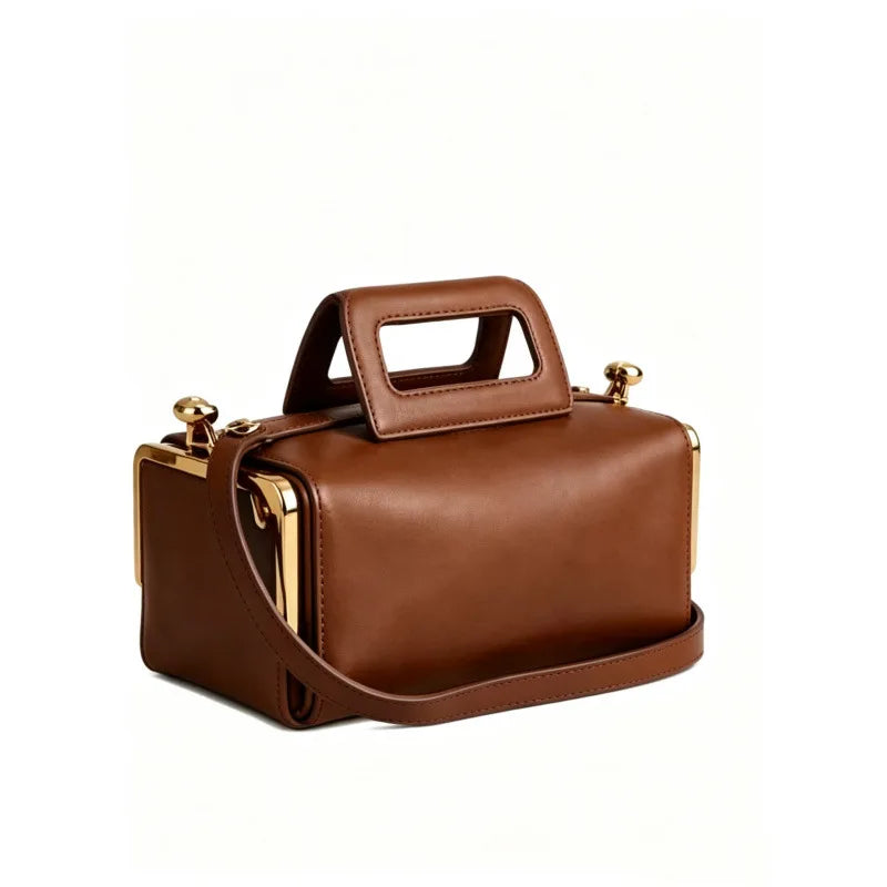 A brown leather handbag with a structured rectangular shape, a top handle, and a shoulder strap, accented with gold-tone hardware, shown on a plain white background.