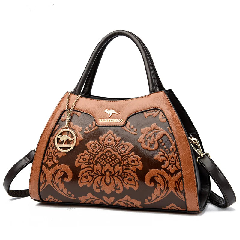 Brown floral-patterned handbag with black accents on a white background