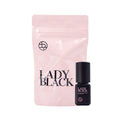 A light pink resealable pouch and a small black bottle labeled LADY BLACK, shown on a plain white background.