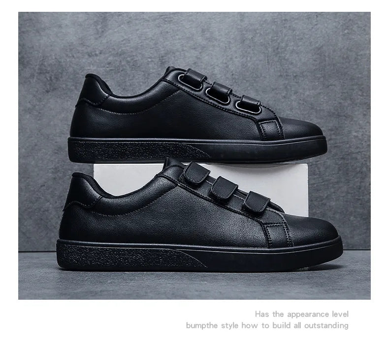 Black sneakers with velcro straps on a gray background