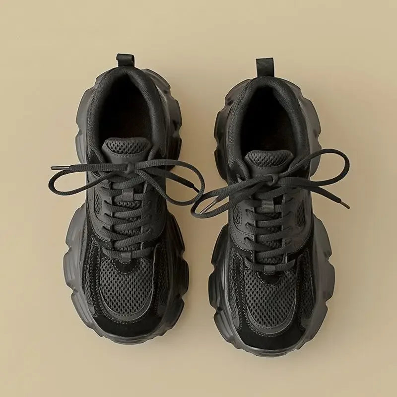 Pair of black sneakers on a beige background