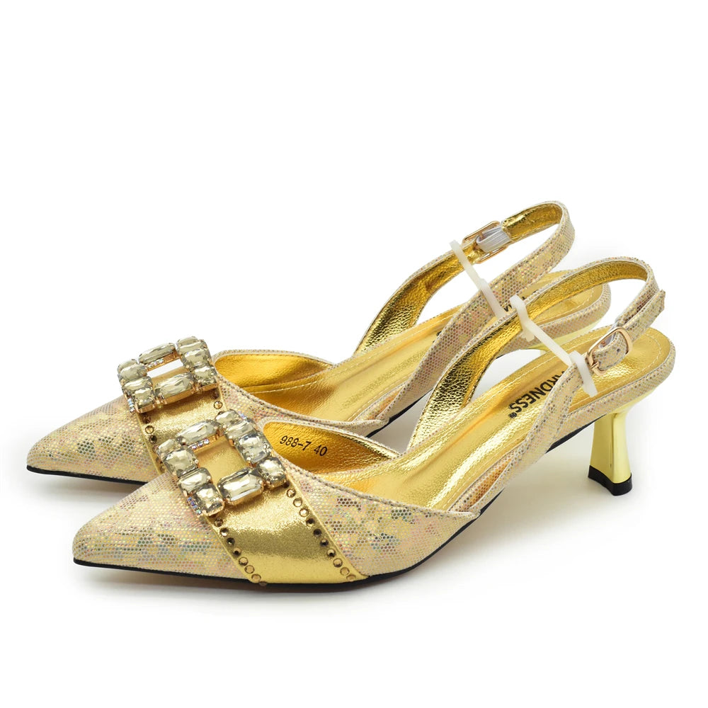 A pair of gold metallic slingback pumps with pointed toes, double crystal-embellished straps, and mid-height heels, shown on a white background.
