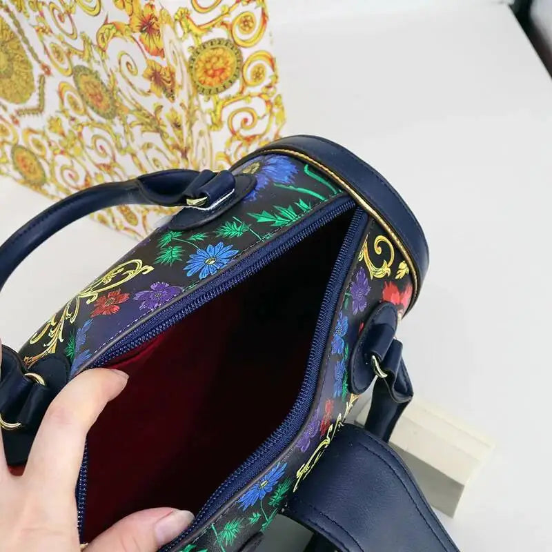 Handbag with floral and paisley pattern held by a hand on a light background