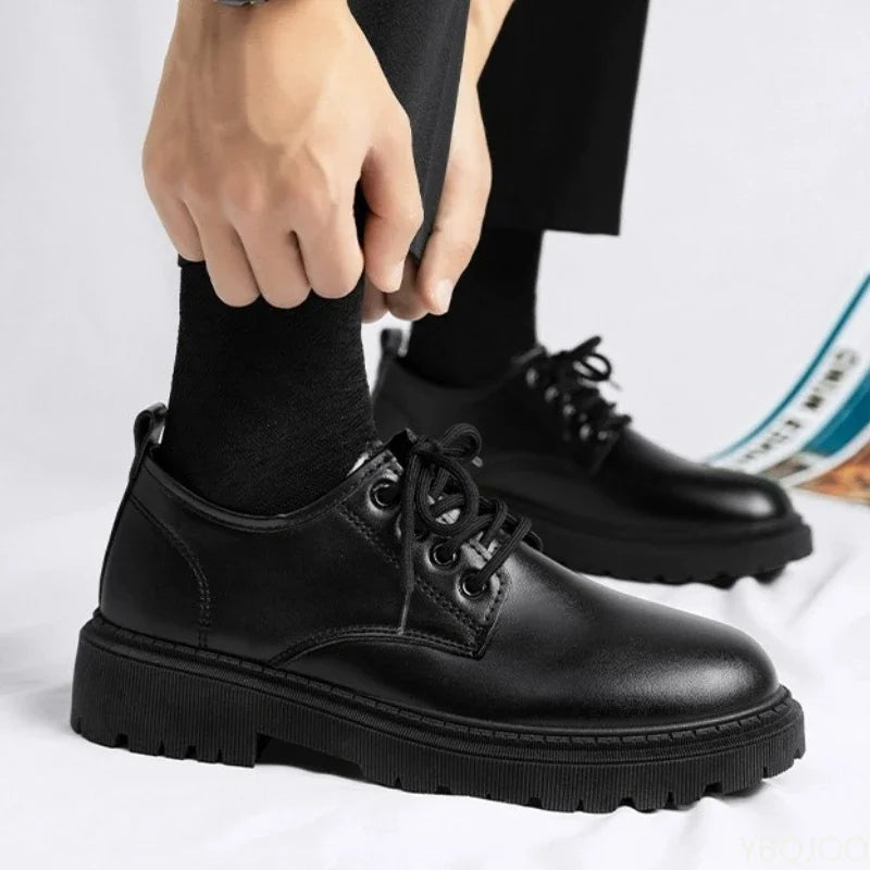 Person wearing black leather shoes with a white background