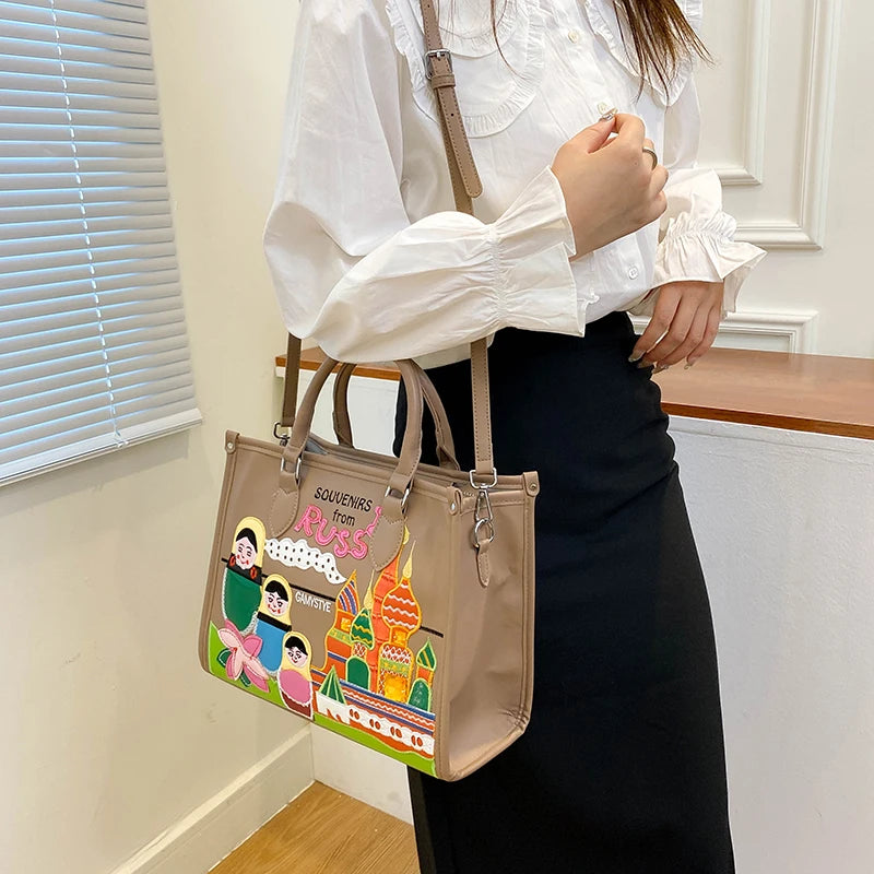 A woman wearing a white blouse and black skirt carries a beige tote bag with colorful cartoon graphics and the text 'SOUVENIR from RUSS'.