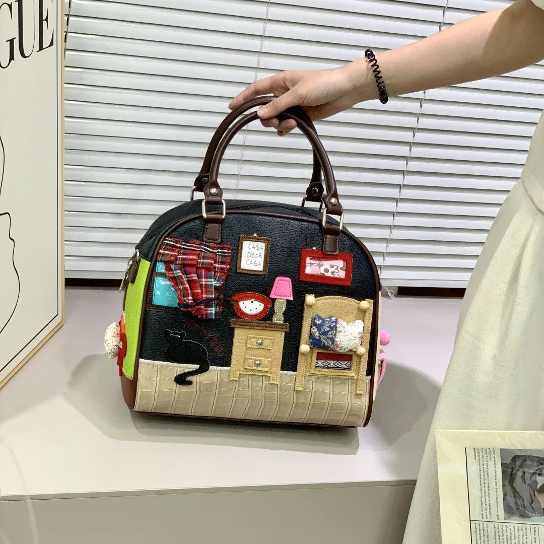 Handbag with miniature room design held by a person, with a window and blinds in the background.