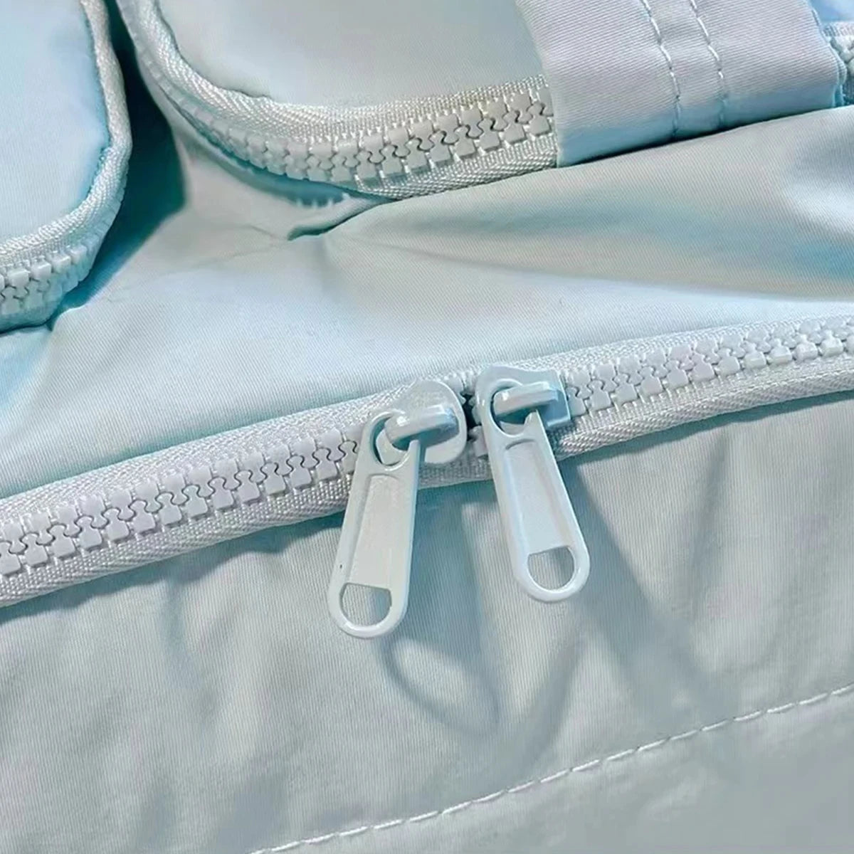 Close-up of a light blue jacket with a zipper