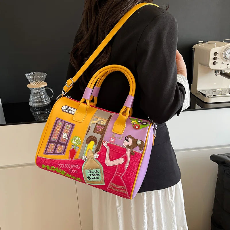 Person holding a colorful handbag with artistic design in a kitchen setting