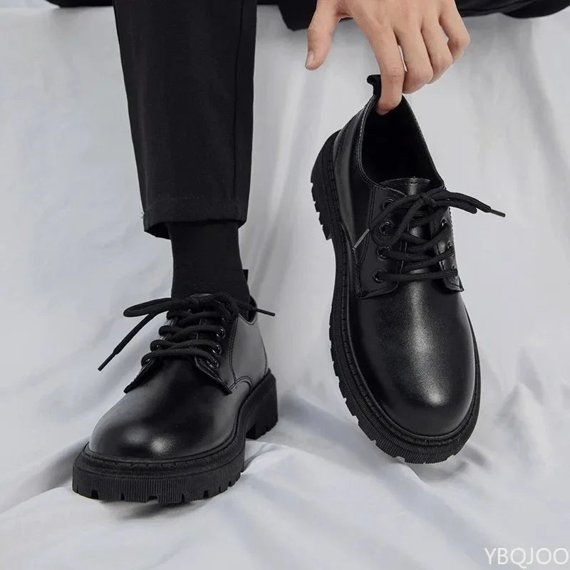 Person wearing black leather shoes with thick soles on a white background