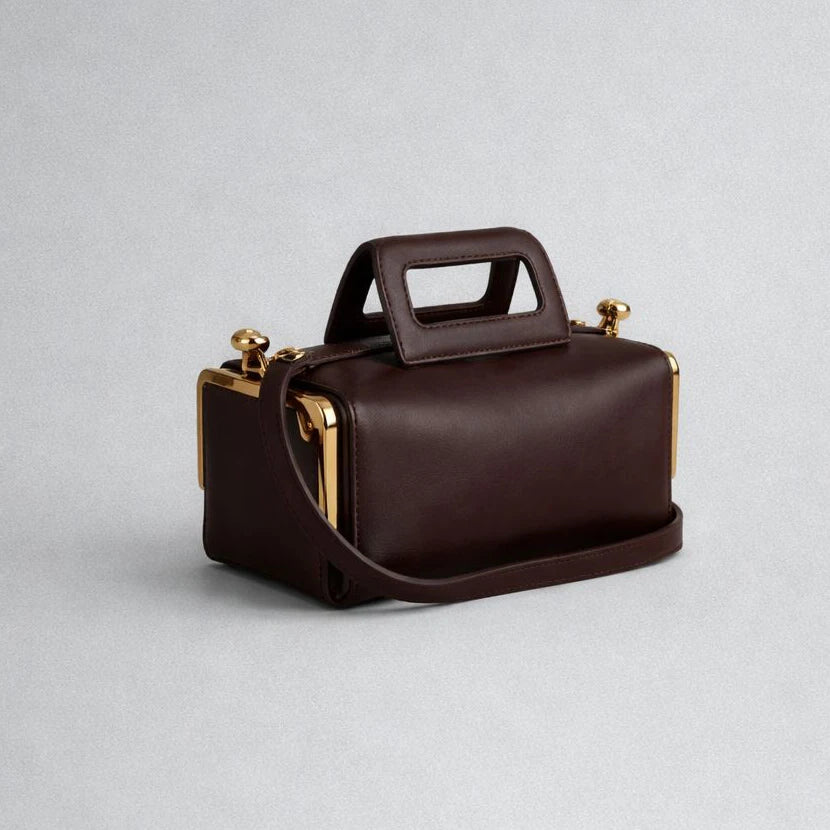 Brown handbag with gold accents on a light gray background