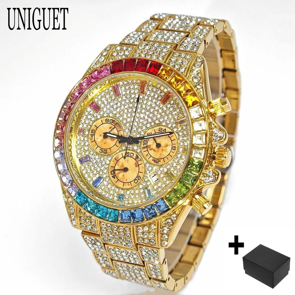 A gold-tone UNIGUET watch covered in clear rhinestones, featuring a colorful rainbow crystal bezel and a gold-tone dial with three subdials. A small black accessory box is shown in the bottom right corner against a white background.