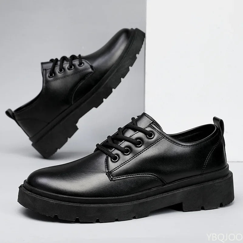 Black leather shoes with thick soles on a light gray background